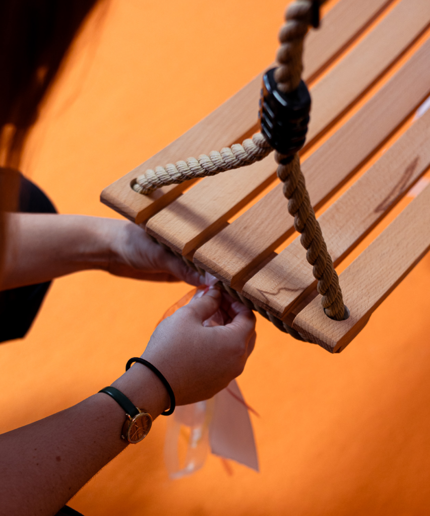 Réglage et finitions d’une balançoire en bois lors de l’installation d’un décor événementiel, détail du savoir-faire Le Grand Décor.