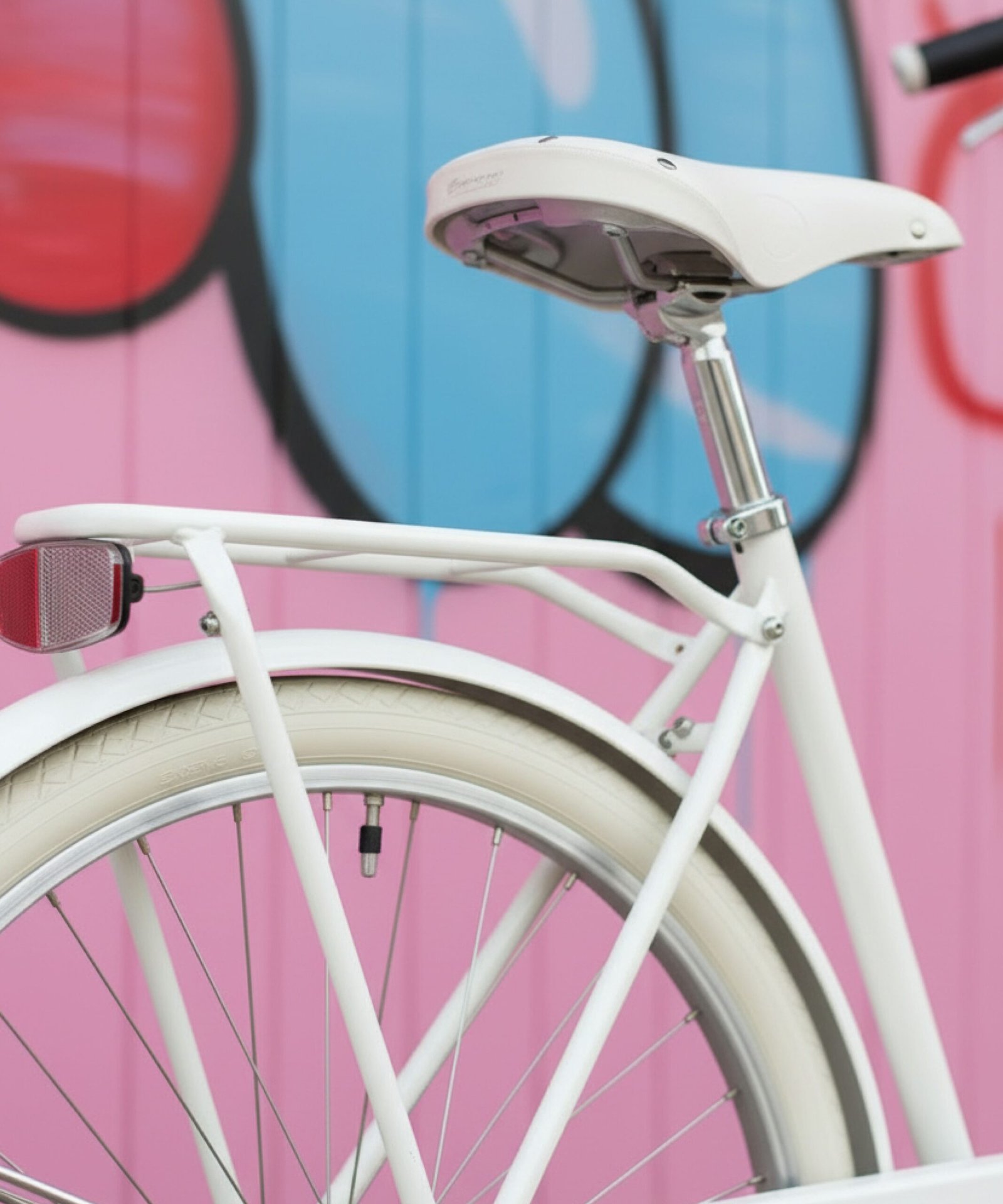 Détail selle blanche et roue arrière vélo vintage blanc.