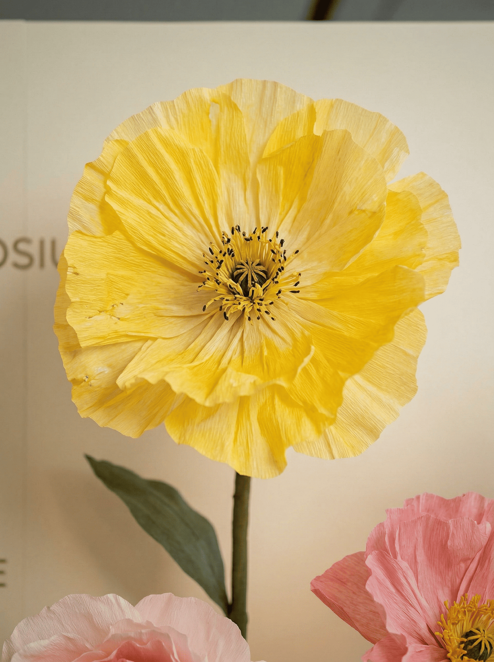 Fleur géante jaune décorative utilisée dans scénographie événementielle.